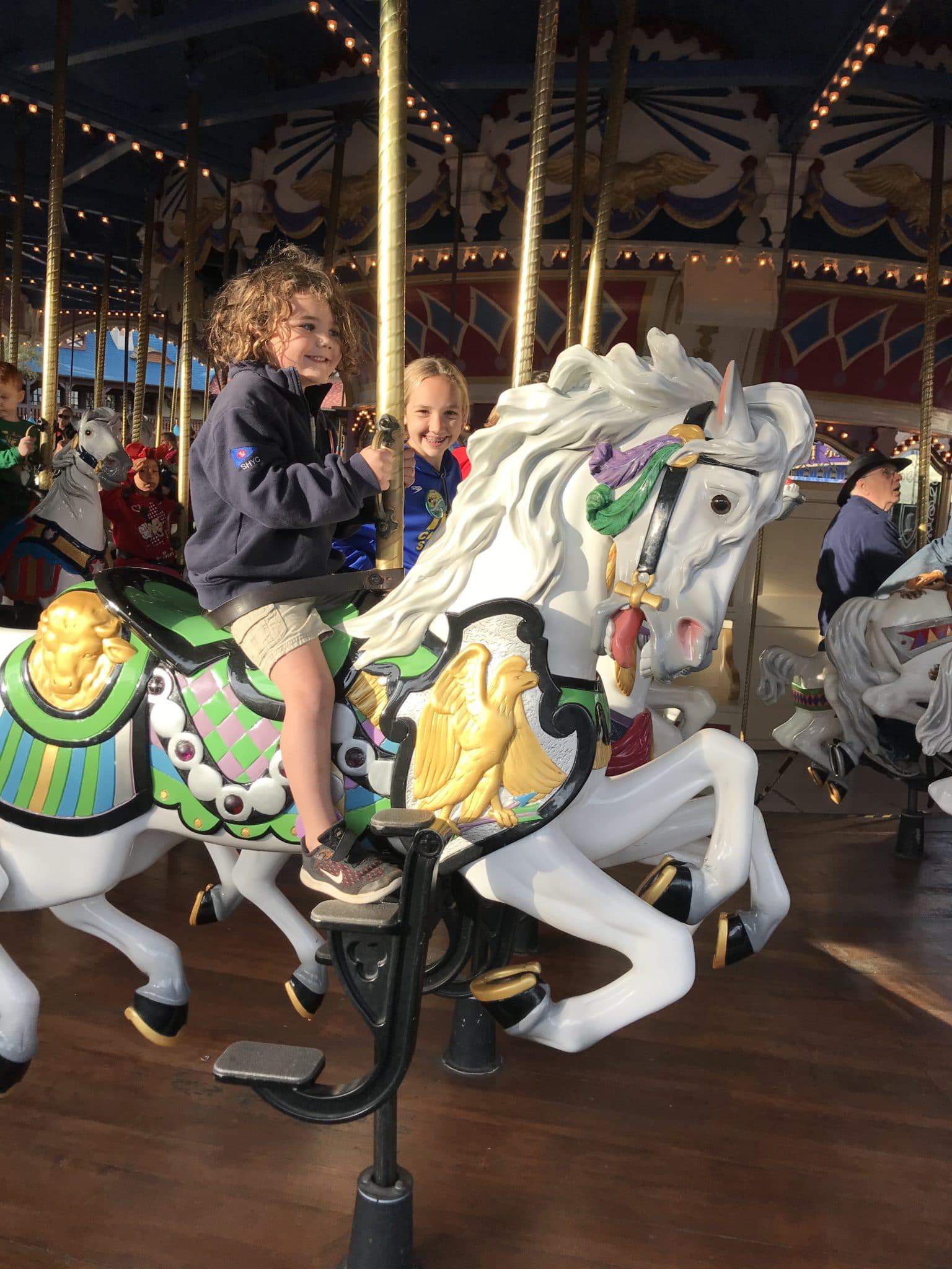 kids on the carousel at magic kingdom