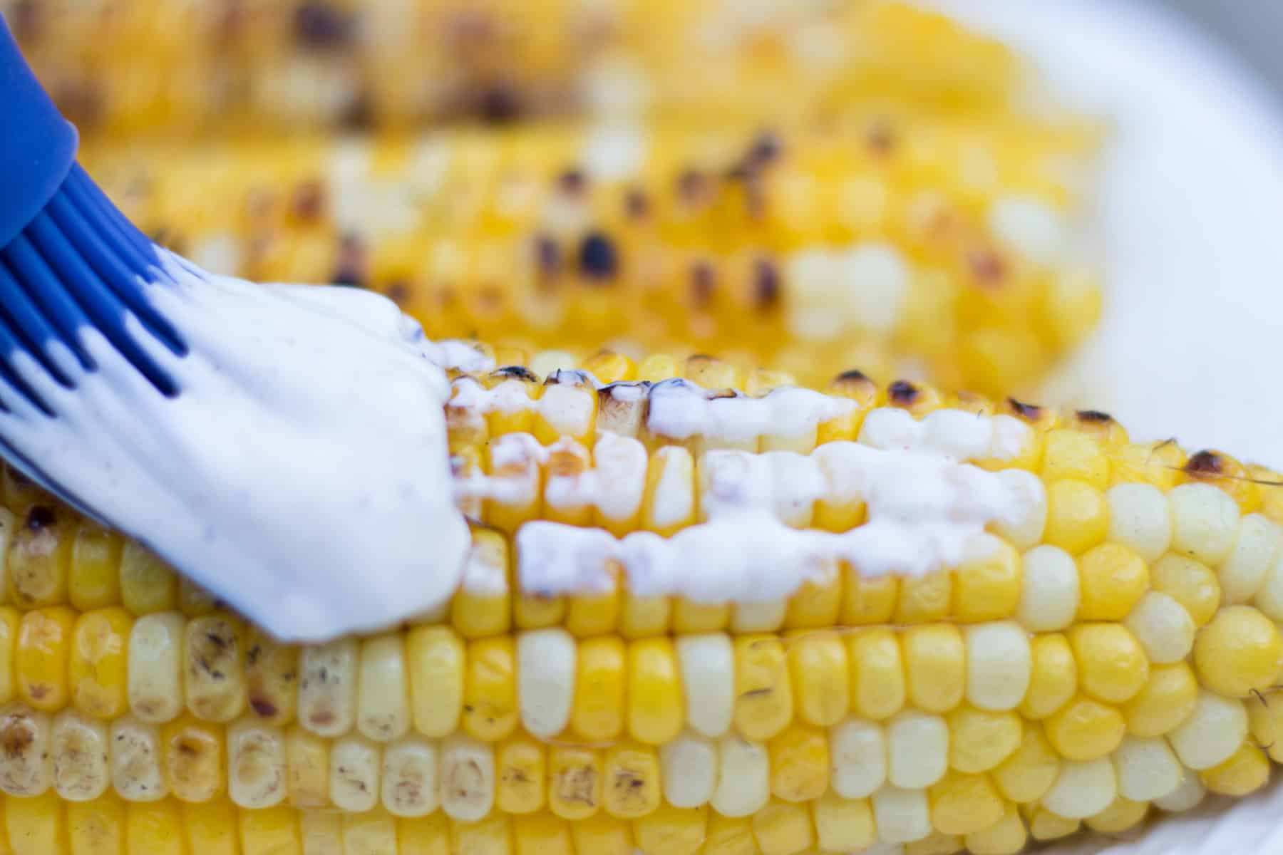 brushing cream on corn