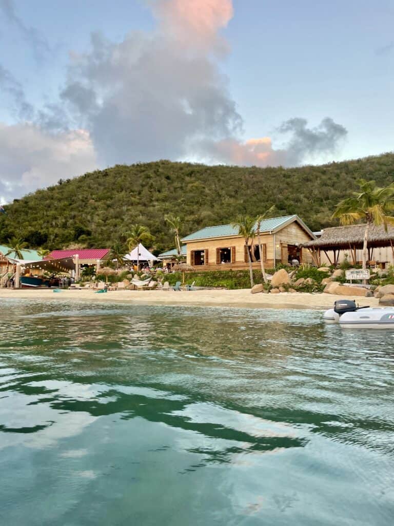 Scenic view of Brighton Beach with calm waters and tropical landscape in the background.